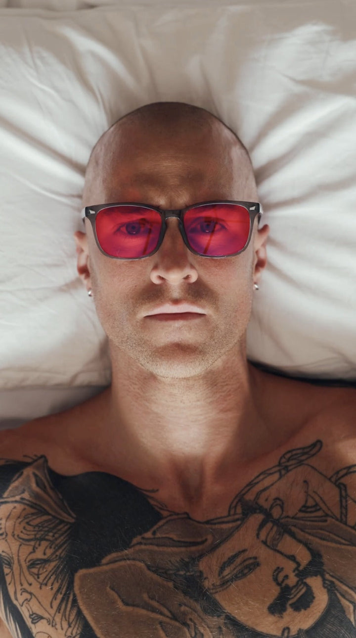 Customer lying in bed wearing 8Hours blue blocking glasses