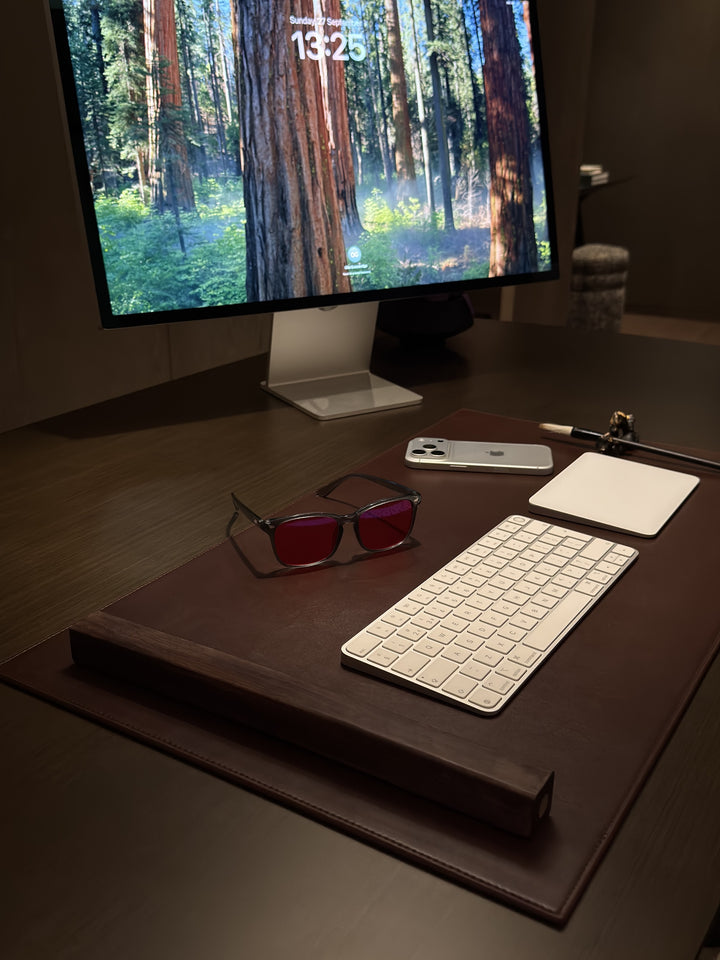 Customer photo: 8HOURS blue blocking glasses on a desk in front of a monitor in the evening