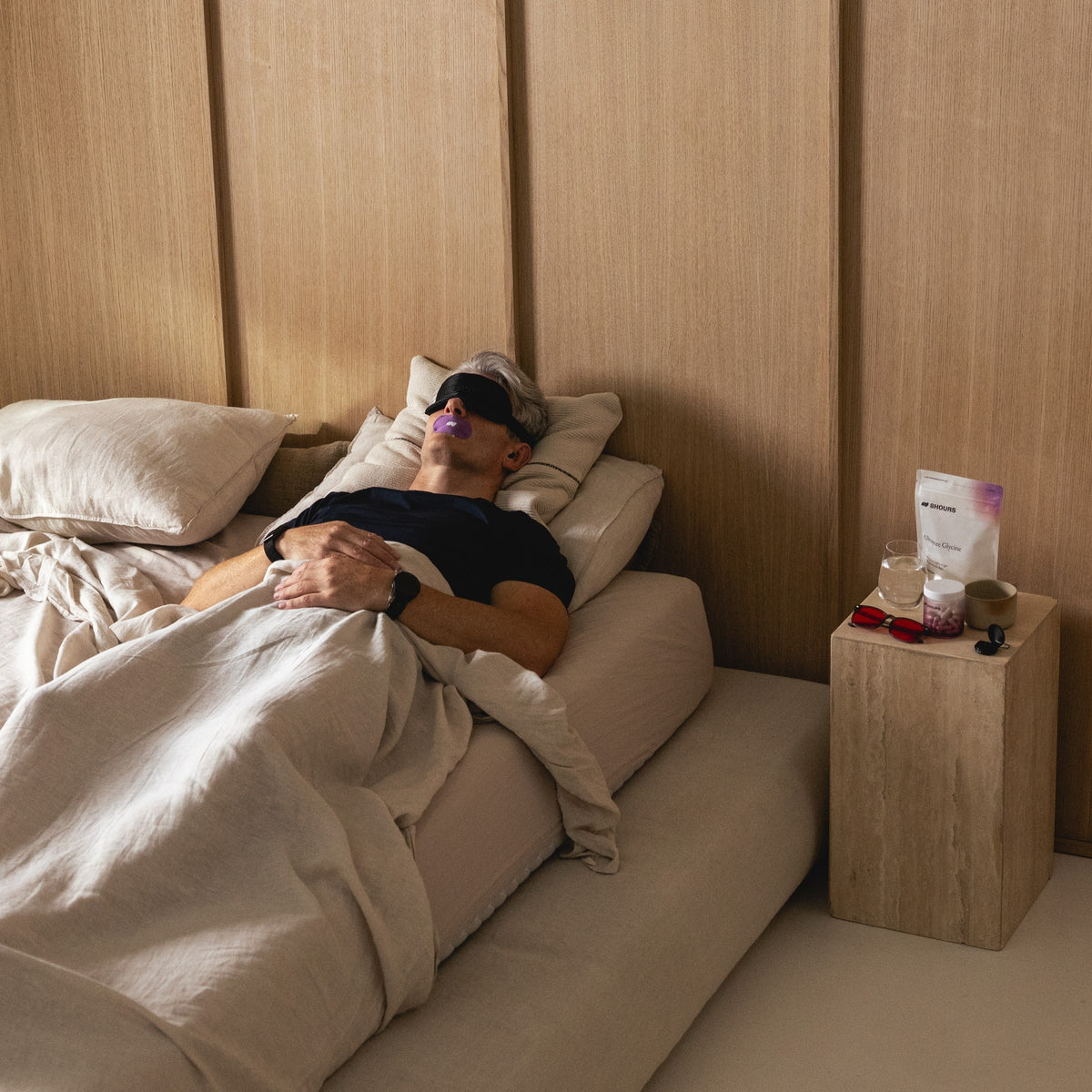 Man asleep in a calm, wood-panelled bedroom