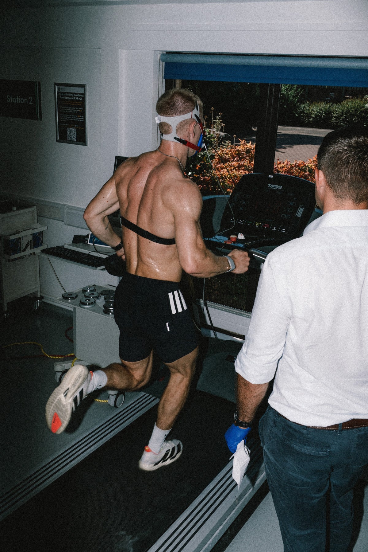 An athlete running a lab treadmill test with a coach watching