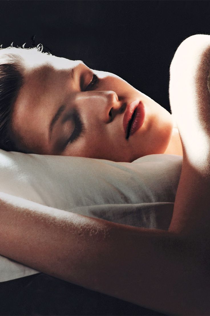 A woman sleeping peacefully in low warm light
