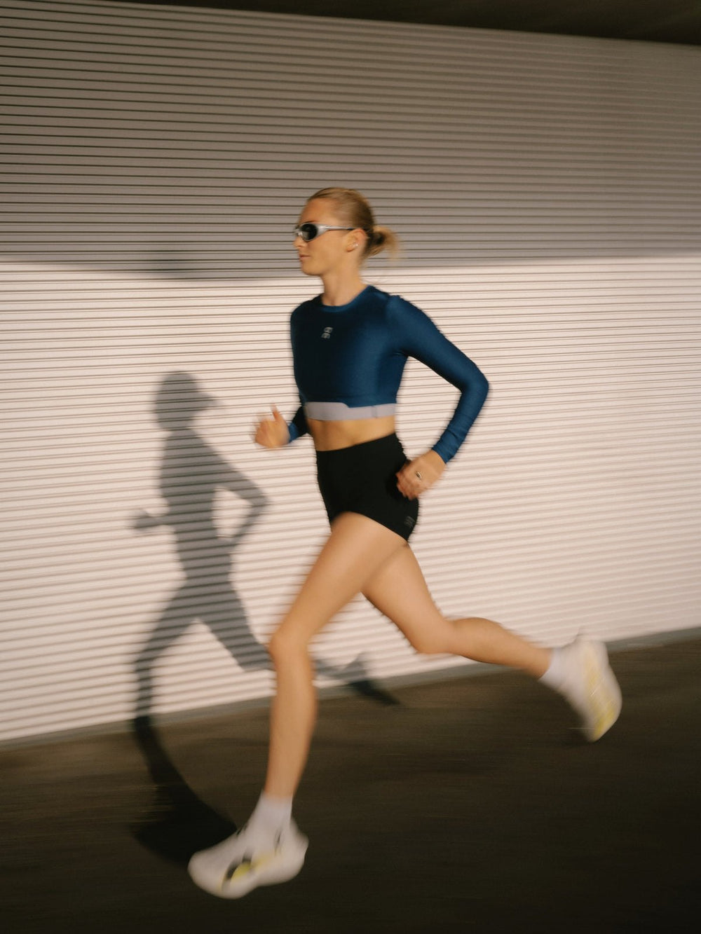 Athena running past a ribbed wall